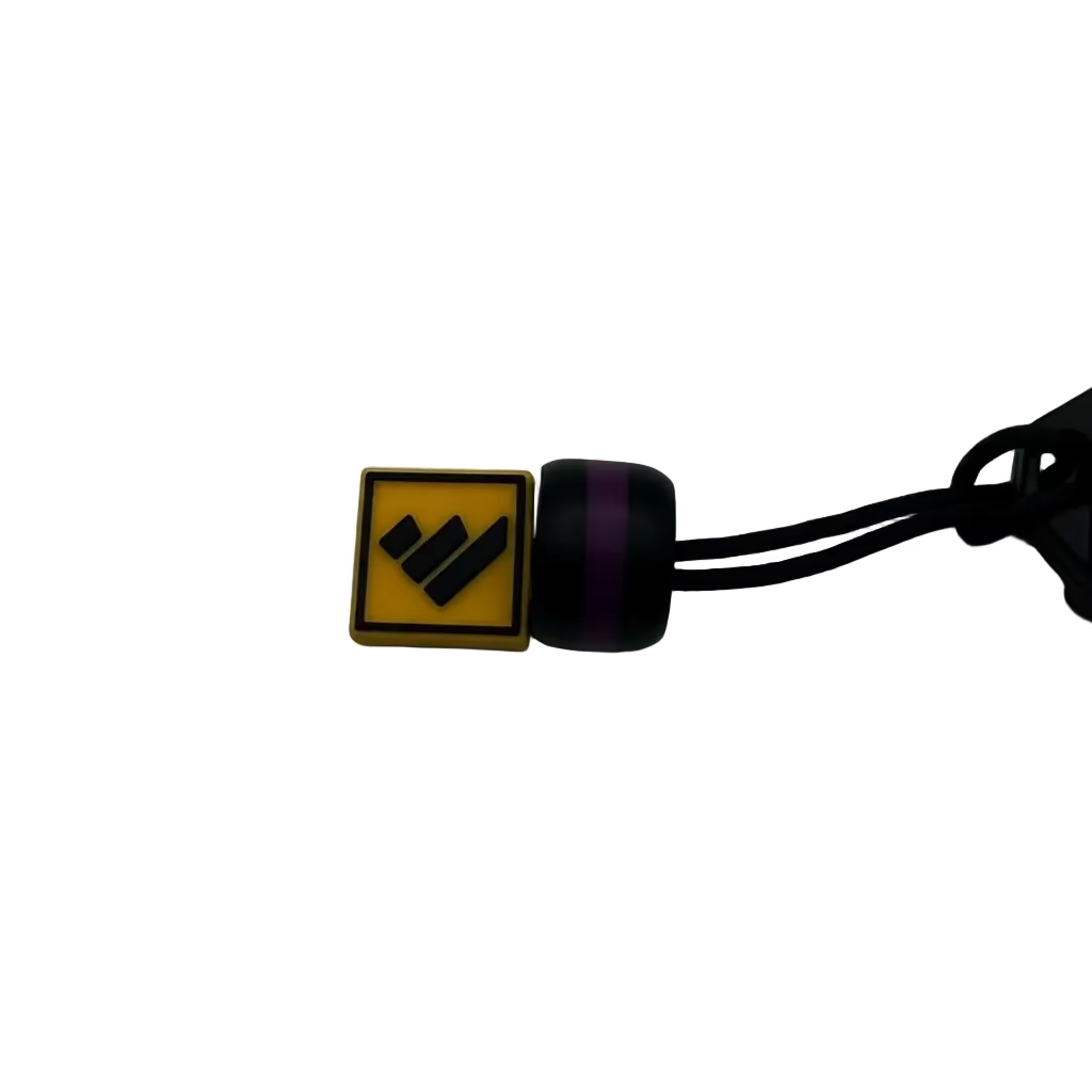A small square yellow and black charm with a black logo, attached to a black cord, photographed on a plain light gray background.