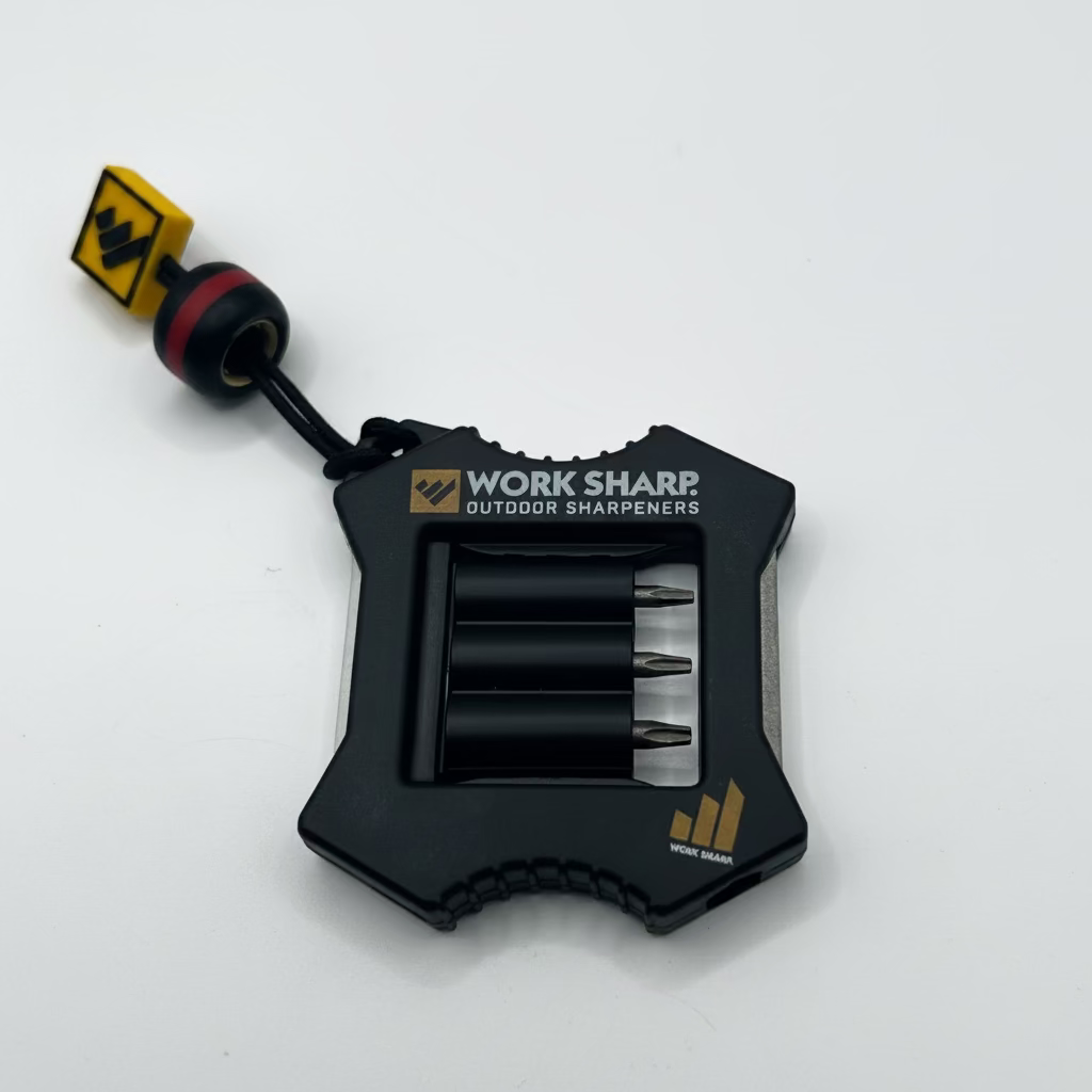 A black Work Sharp outdoor sharpener with a lanyard and keychain attachment, shown on a plain light gray background.